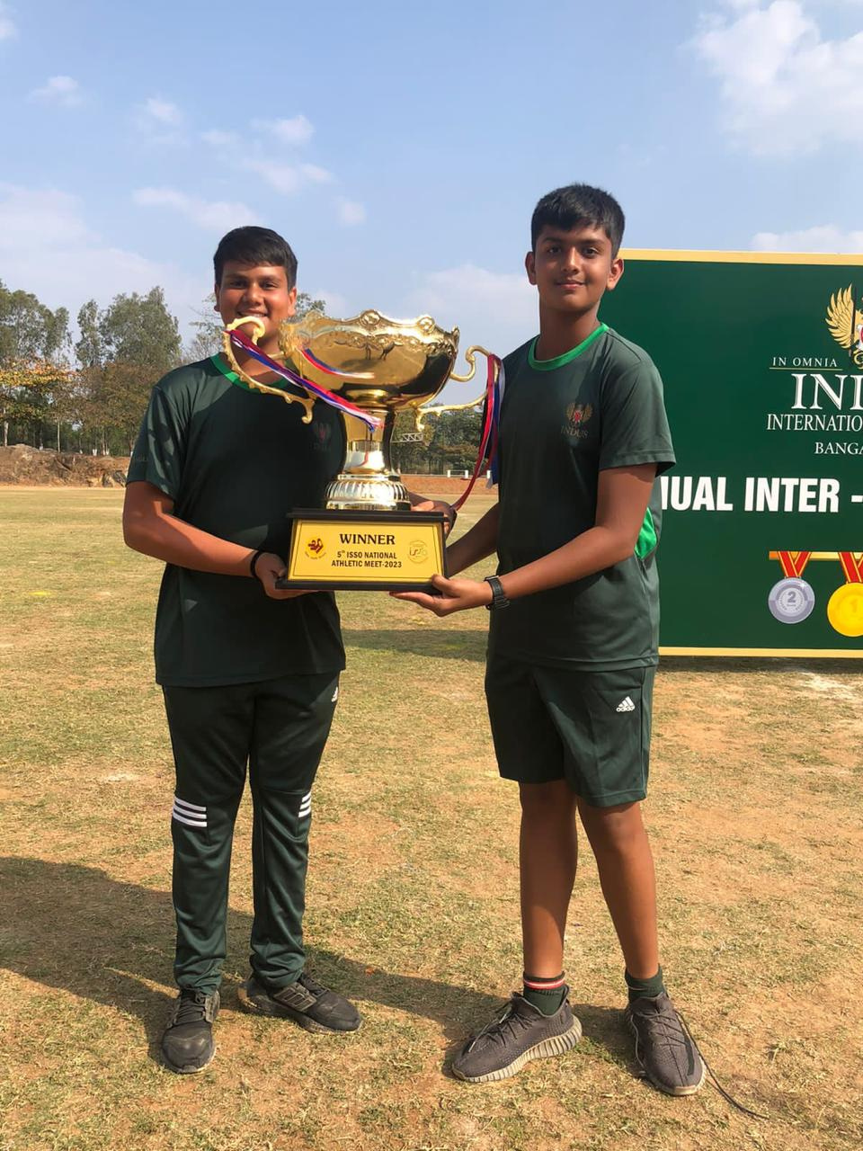 Pranay holding a large winner's trophy at an athletics meet