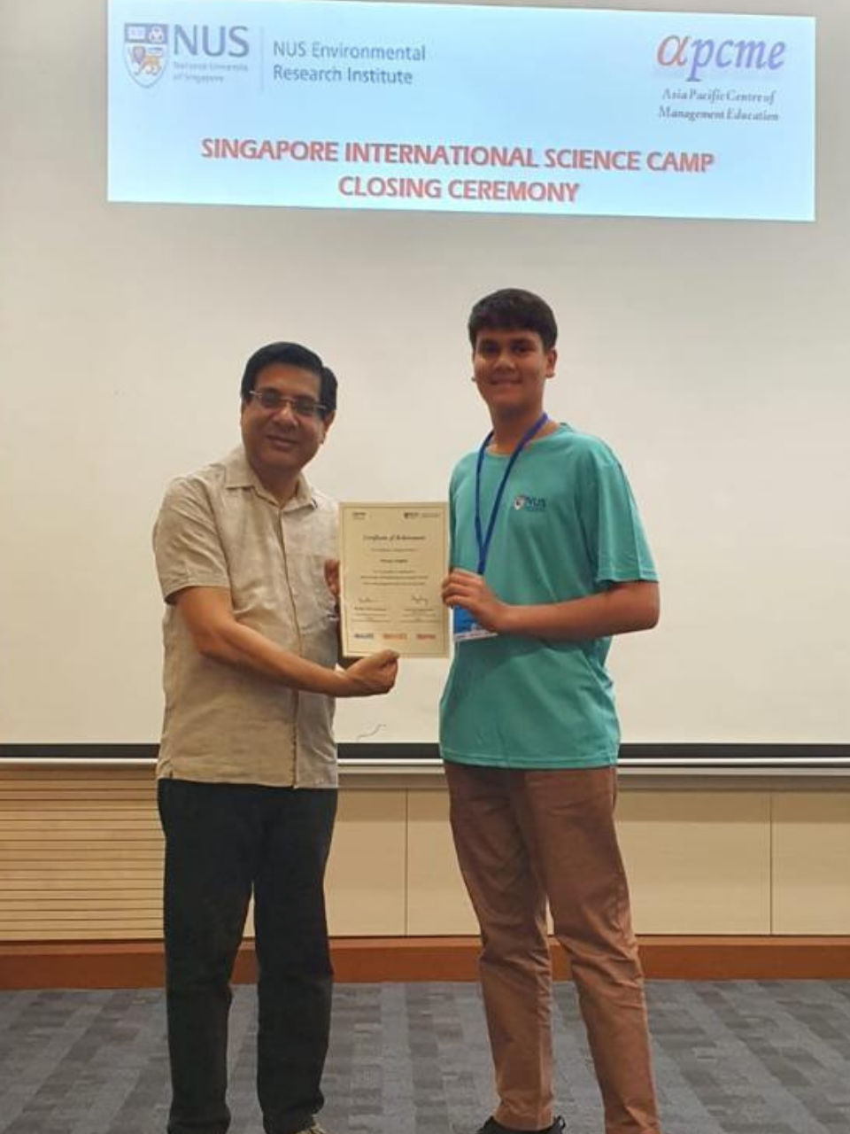 Pranay receiving a certificate at a Singapore science camp