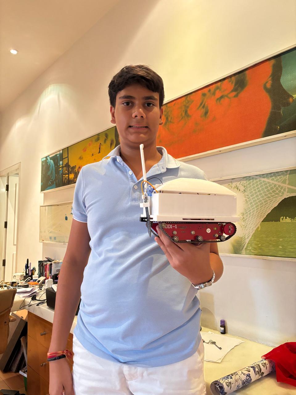 Pranay holding the Kheti Insight agricultural robot he built
