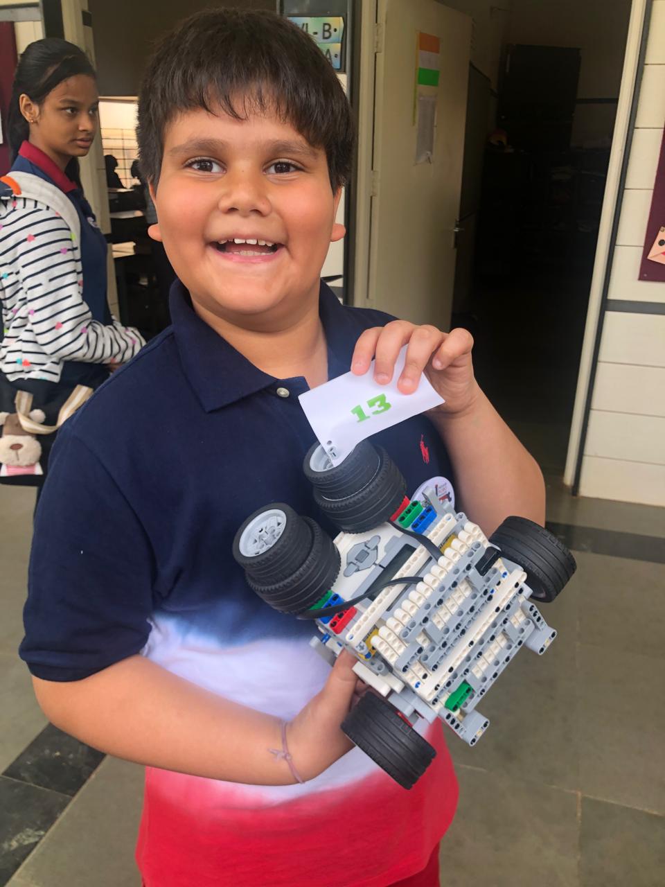 Pranay holding a modular LEGO robotics build